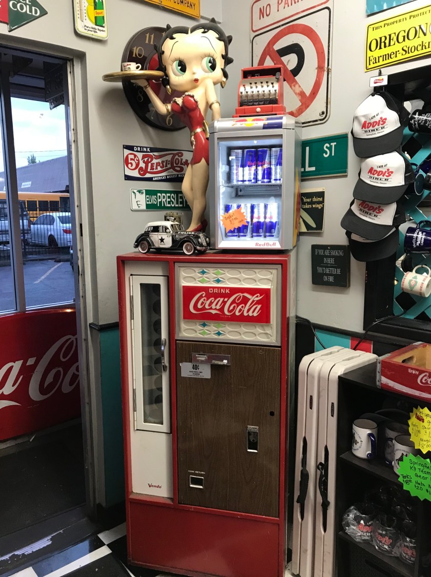 Betty Boop on top of a vintage Coca Cola vending machine