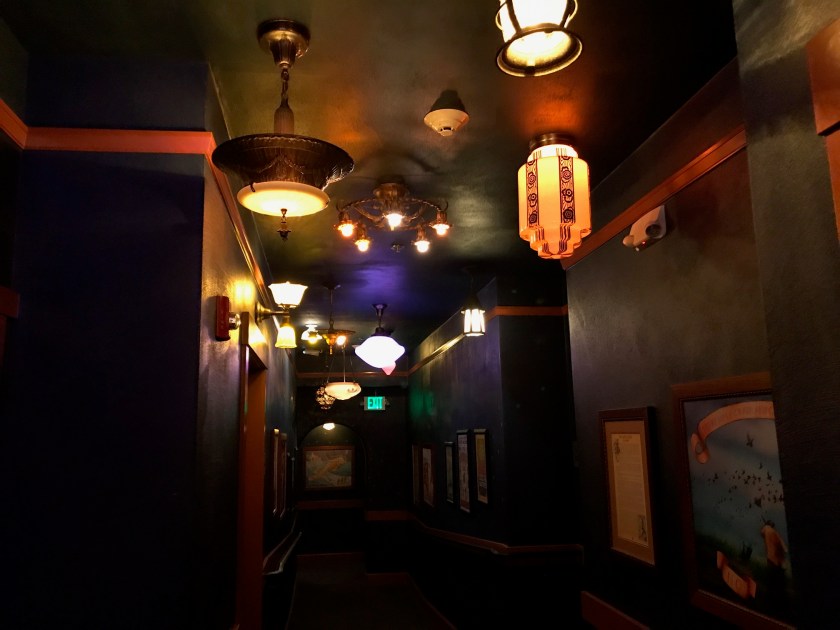 Looking down the hallway at the different lights and dark paint along walls and ceiling