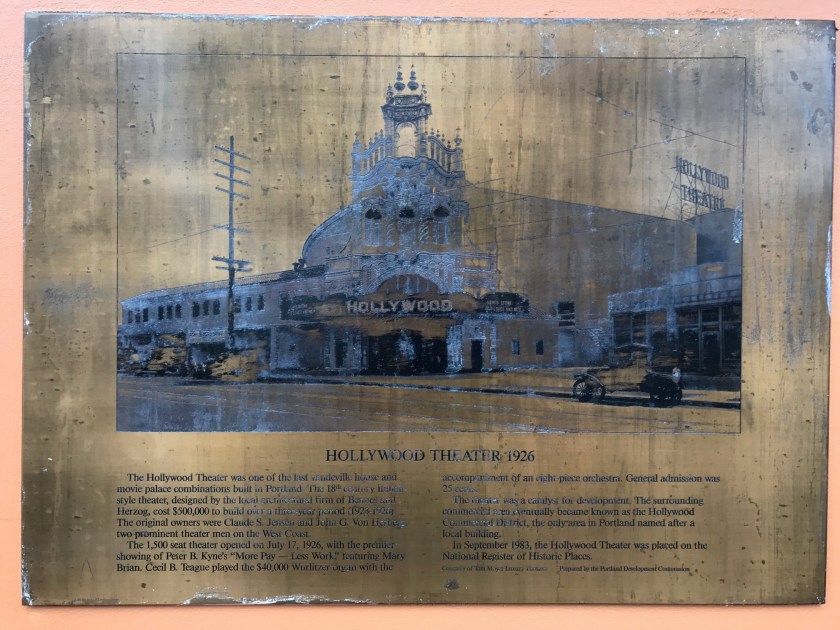 Brass sign on wall of Hollywood Theater explaining past and other facts