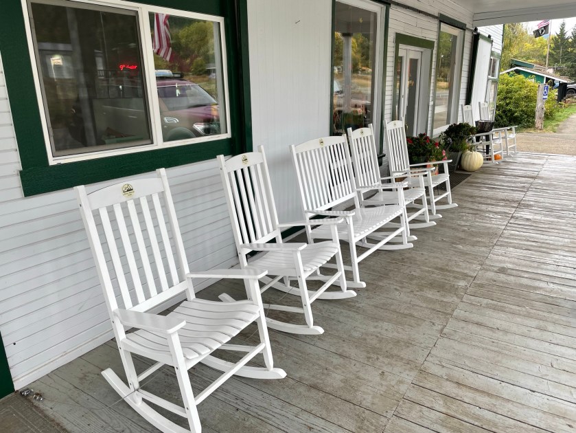 Line of white painted rocking chairs.